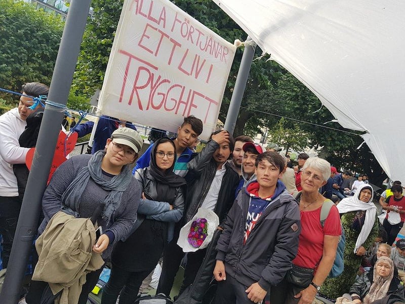 Reza Rezaie, ensamkommande bosatt Ystad, pustar ut omgiven av skånska vänner efter att ha medverkat med egenskriven musik i dagens demonstration mot utvisningarna till Afghanistan.