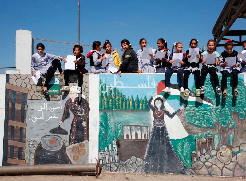 Palestinska skolflickor sitter på en mur utanför kvinnocentret Dalal Mughrabi som namngivits efter terroristen Dalal Mughrabi som 1978 var delaktig i en blodig terrorattack på en väg mellan Tel Aviv och Haifa där över 30 personer omkom.