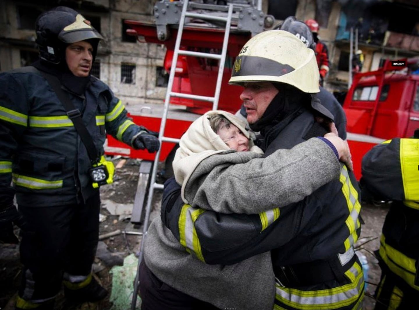 Ukrainsk brandman får en kram av en äldre kvinna.