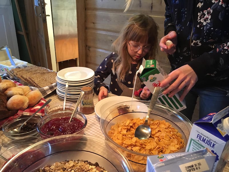 Gästerna på gården njuter av hembakat bröd till frukosten. Här är det Elsie, 5 år, som laddar med gröt inför en dag i skidbacken.