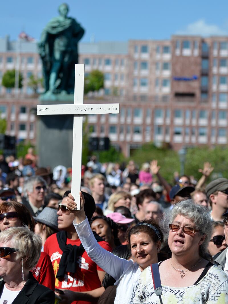 En kvinna håller i ett vitt kors.