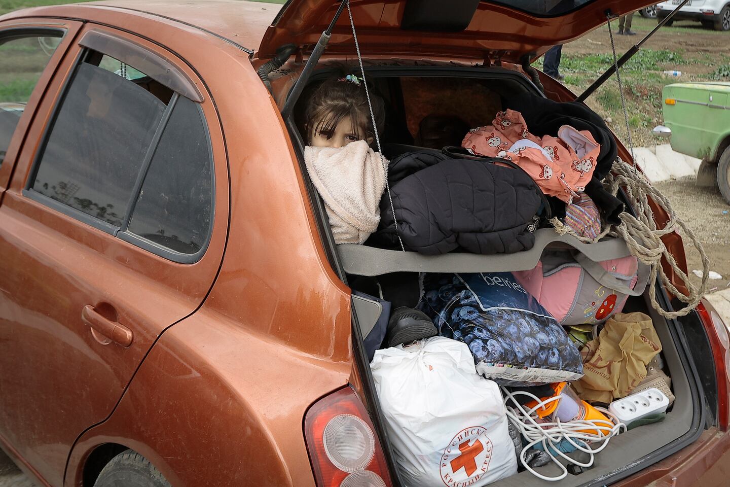 En flicka tittar ut från den fullastade bilen då flykten går till Armenien.