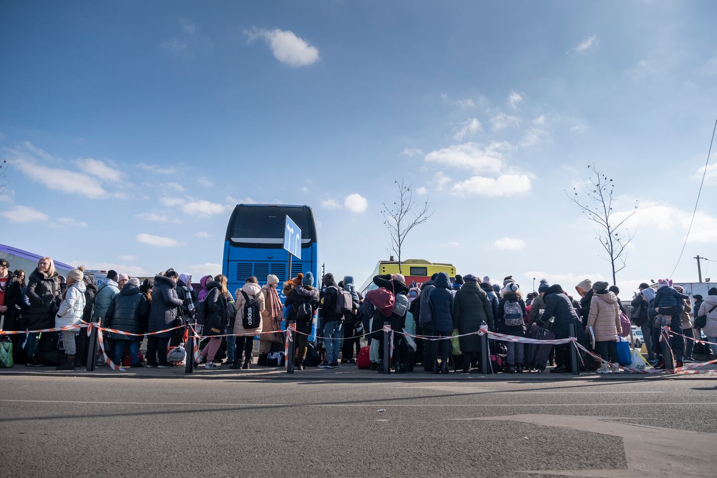 Flyktingar köar till gratisbussar som går över gränsen till Polen.