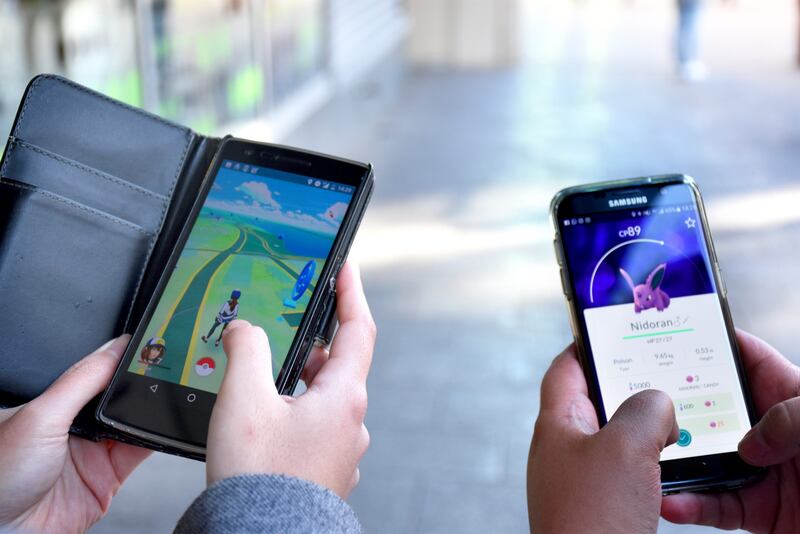 Två personer spelar mobilspelet Pokémon Go. 