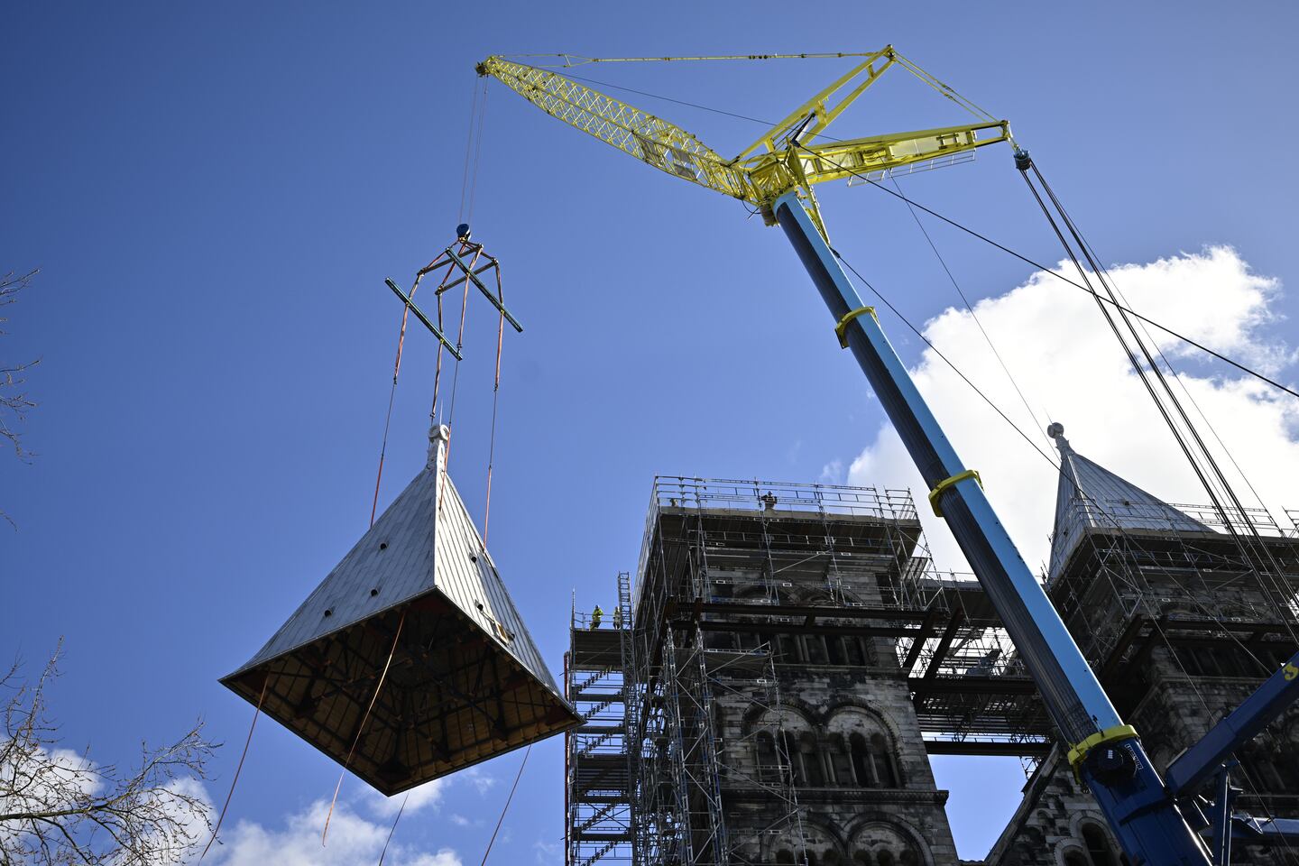 De renoverade tornen på Lunds domkyrka återställs med hjälp av en kran.