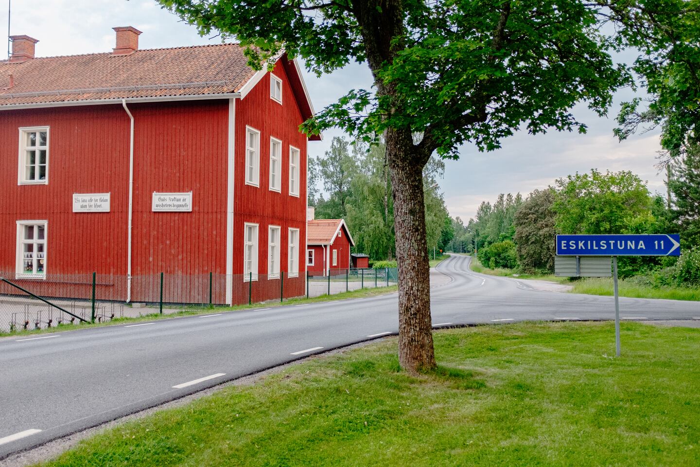 Skylten på den gamla skolan i orten Kjula. Där står, i sirliga bokstäver, “Guds fruktan är vishetens begynnelse”, ett bibelcitat från Psaltaren 111.