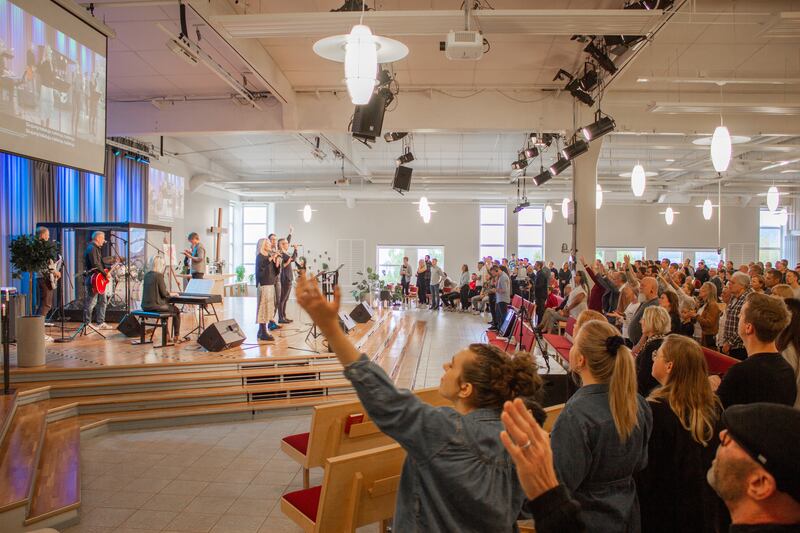 Människor i en kyrka lovsjunger Gud.