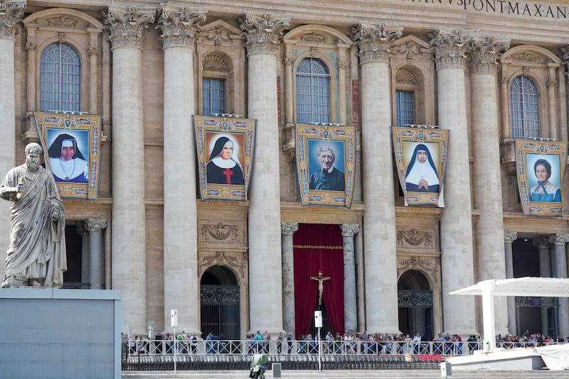 John Henry Newman kanoniseras tillsammans med fyra kvinnor: Dulce Lopes Pontes, Giuseppina Vannini, Maria Teresa Chiramel Mankidiyan, och Margarita Bays. Porträtten av de nya helgonen pryder här väggarna inför söndagens ceremoni.