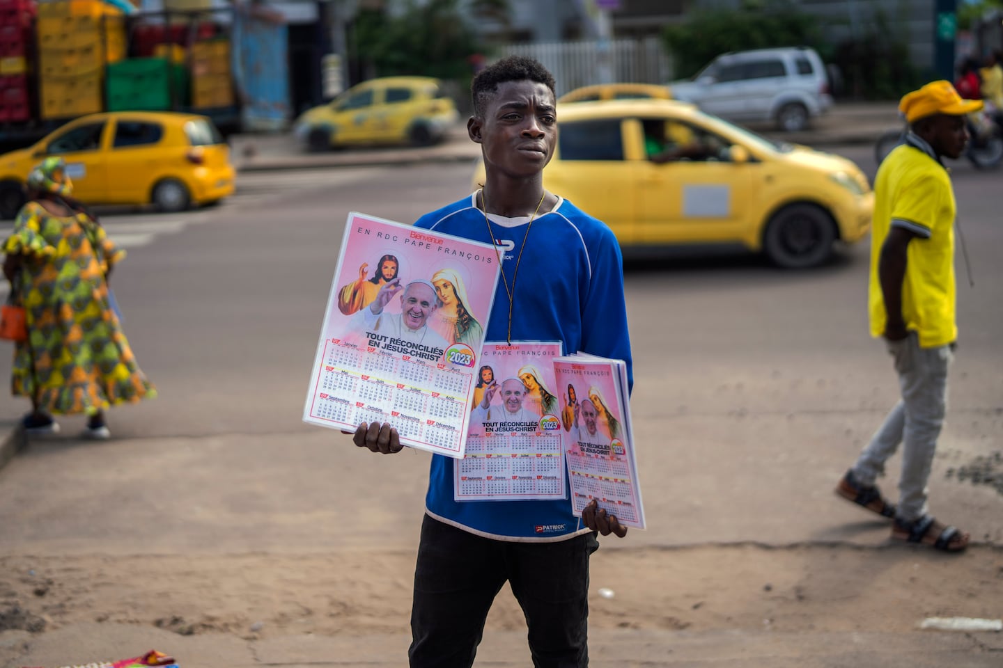 En pojke säljer kalendrar med påve Franciskus på utanför katedralen Vår fru av Kongo i huvudstaden Kinshasa.