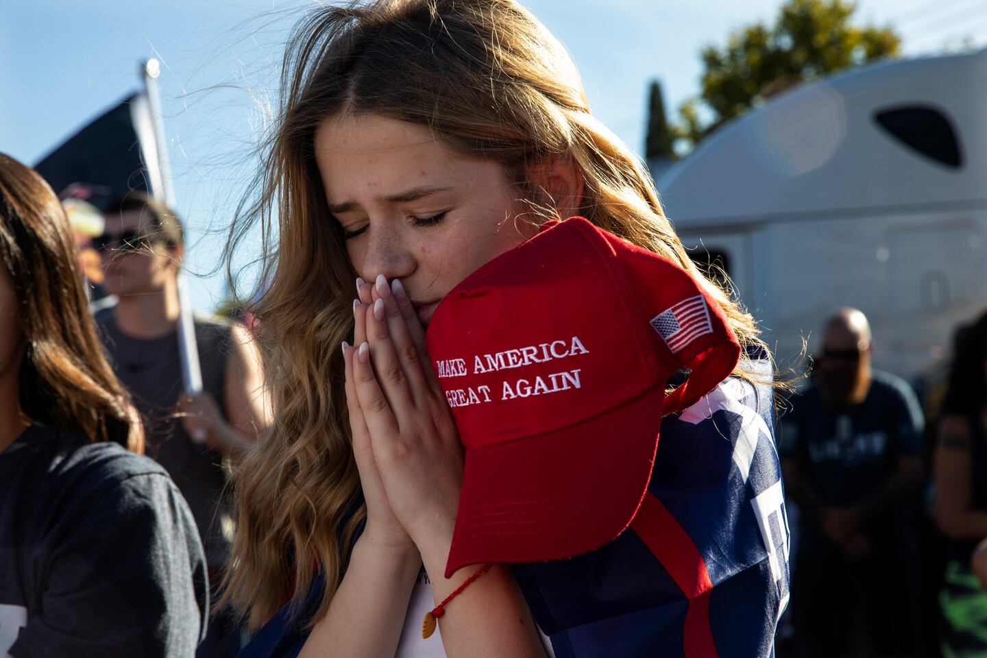 Liza Durasenko, 16 år, ber och håller en Make Amerika Great Again-keps.