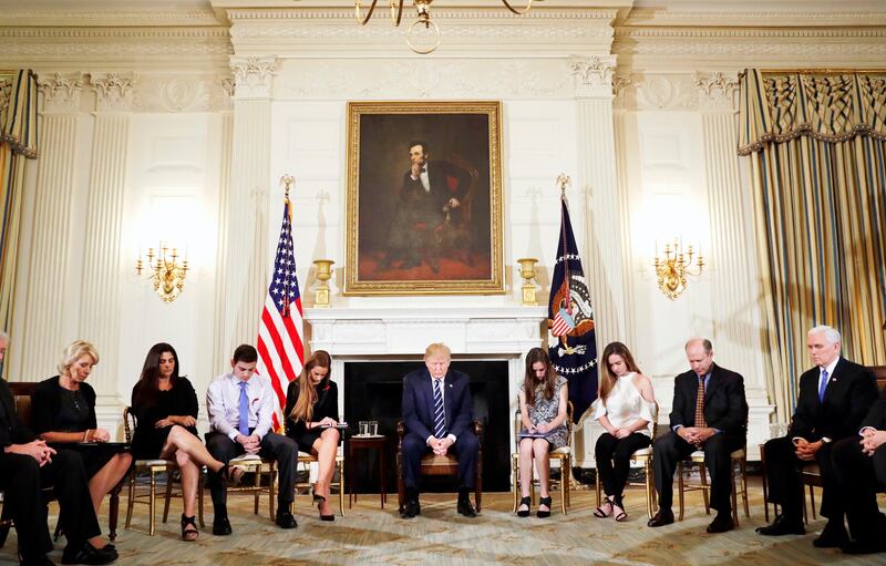 President Donald Trump bows his head during an opening prayer at the start of a listening session with high school students and teachers in the State Dining Room of the White House in Washington, Wednesday, Feb. 21, 2018. (AP Photo/Carolyn Kaster)