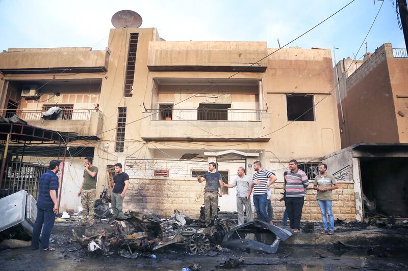 People gather after a car bomb exploded in the town of Qamishli, Syria, Friday, Oct. 11, 2019. Turkish forces faced intense resistance by U.S.-allied Syrian Kurdish fighters on the third day of Ankara's offensive, as casualties mounted, international criticism of the campaign intensified and an estimated 100,000 people fled the violence. (AP Photo/Baderkhan Ahmad)  DV111